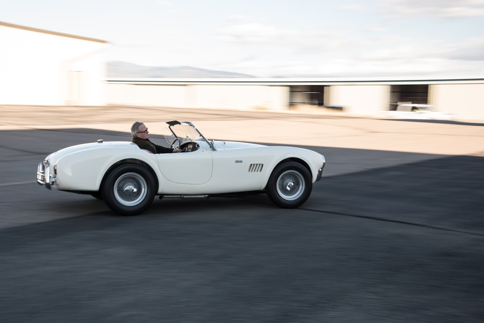 Collector roadster moving through late afternoon light